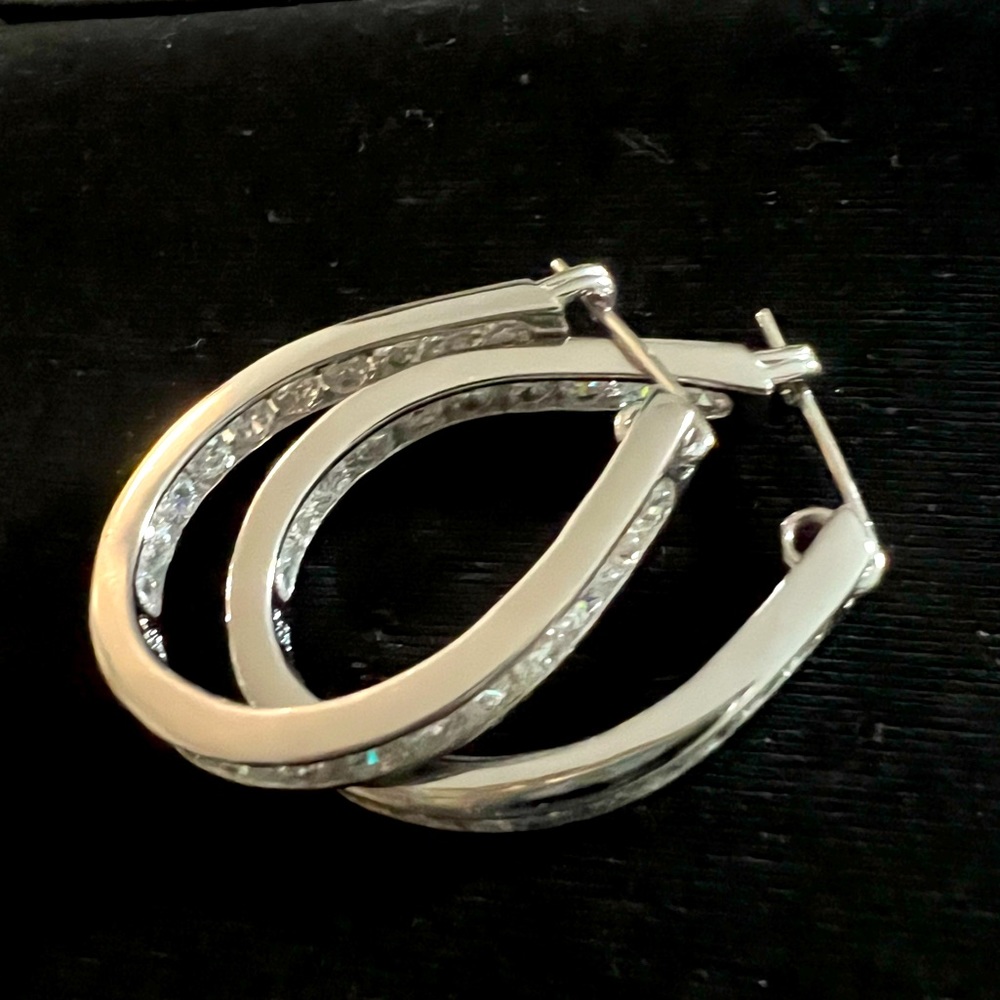 Sterling silver and cubic zirconia hoop earrings.